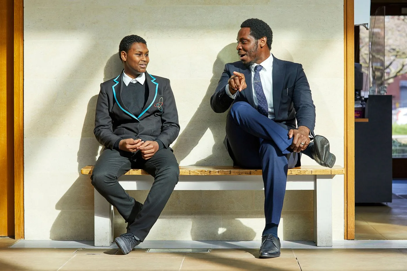 A TLG student and their mentor sitting on a bench in conversation